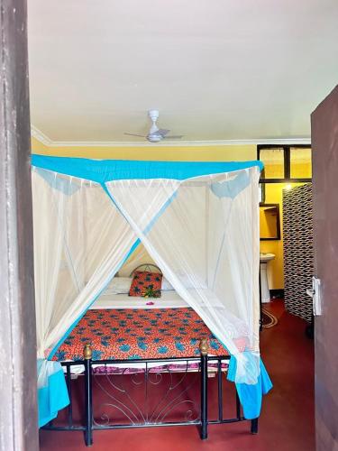 a bed with a canopy in a room at Juani beach bungalows in Kilindoni