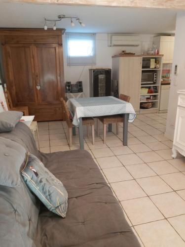 a living room with a table and a kitchen at APPARTEMENT T2 PLAIN PIED in Labastide-Saint-Georges