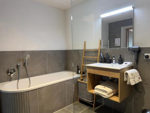 a bathroom with a tub and a sink and a shower at stadtwirt bruck in Vöcklabruck