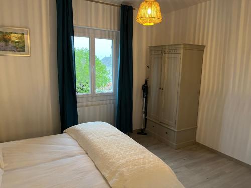 a bedroom with a bed and a window and a lamp at Aux Primevères in Saint-Honoré-les-Bains