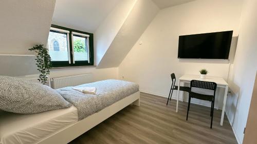 a bedroom with a bed and a desk with a television at Monteurunterkunft Komfort Plus in Hörstel