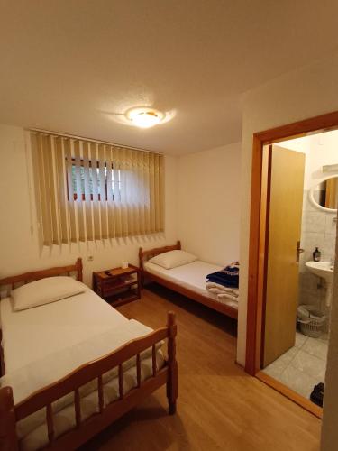 a bedroom with two beds and a mirror at Prenociste Cazin in Cazin