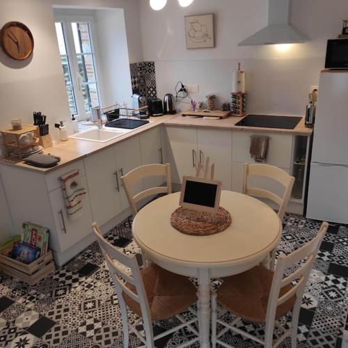 - une cuisine avec une table et un ordinateur portable dans l'établissement Séjour champêtre et bucolique, à Saint-Maurice-sur-Fessard