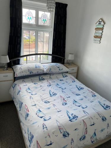 a bed with a white comforter with planes on it at San Remo in Paignton