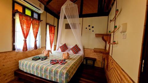 a bedroom with a bed with bow ties on it at Longtail Beach Resort in Thong Nai Pan Yai