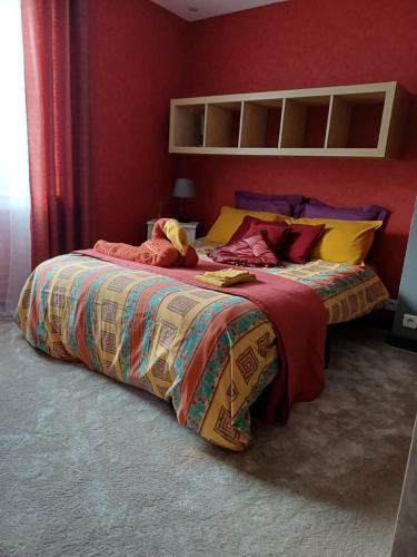 - une chambre avec 2 lits aux murs rouges dans l'établissement Appartement en centre ville, à Gien