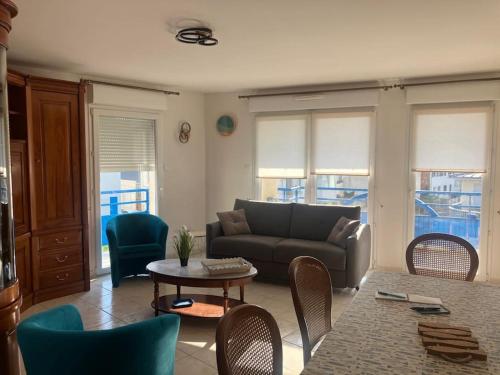 un salon avec un canapé, une table et des chaises dans l'établissement Appartement en résidence de standing, à Berck-sur-Mer