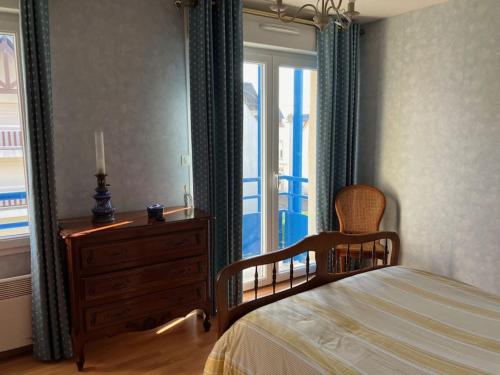 une chambre avec un lit, une commode et une fenêtre dans l'établissement Appartement en résidence de standing, à Berck-sur-Mer