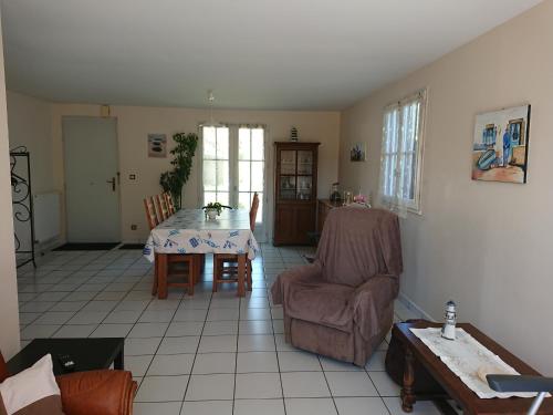 un salon avec une table et des chaises dans l'établissement Plage et tranquilité, à Saint-Brévin-les-Pins