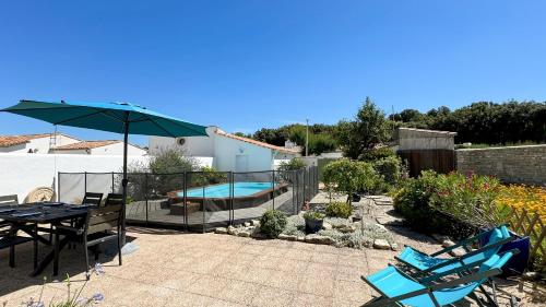 un patio avec une table et des chaises et une piscine dans l'établissement Jolie maison au calme avec piscine, à Rivedoux-Plage