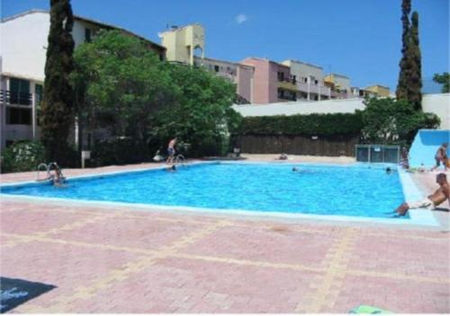 une grande piscine bleue avec des gens dedans dans l'établissement Studio Cabine 4 personnes Cap d'Adge, au Cap d'Agde