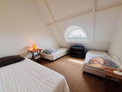 - une chambre avec 2 lits et une fenêtre cintrée dans l'établissement Maison spacieuse à Quiberon, 5 pièces, 140m², proche plage, jardin, calme et confort - FR-1-478-297, à Quiberon