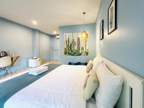 a large white bed in a room with blue walls at Kiri Tawan in Baan Tai
