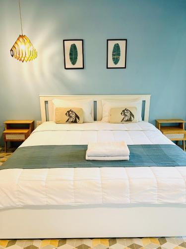 a bedroom with a large white bed with two pillows at Kiri Tawan in Baan Tai