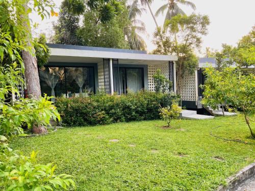 a small house with a grassy yard at Kiri Tawan in Baan Tai