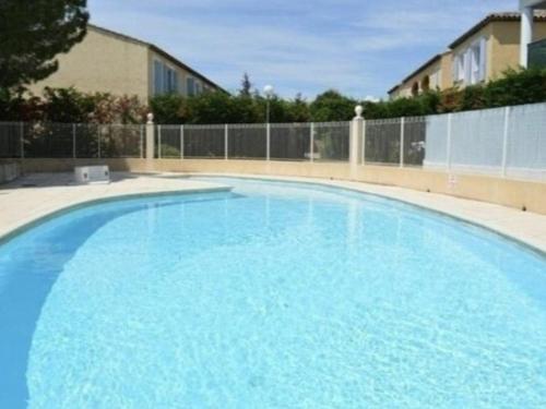 une grande piscine bleue en face d'une clôture dans l'établissement Sainte-Maxime : T2 calme avec piscine, terrasse, proche plages et commerces - FR-1-226-552, à Sainte-Maxime