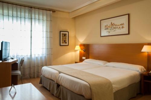 Cette chambre comprend un grand lit et une fenêtre. dans l'établissement Hotel Mercado by gaiarooms, à Salamanque