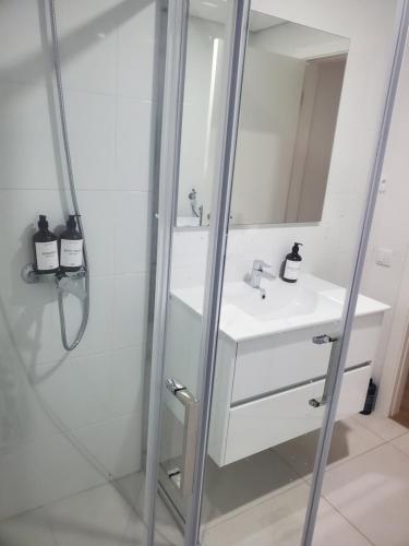 un bagno con lavandino e doccia con specchio di Charming Jasmin House a Viseu