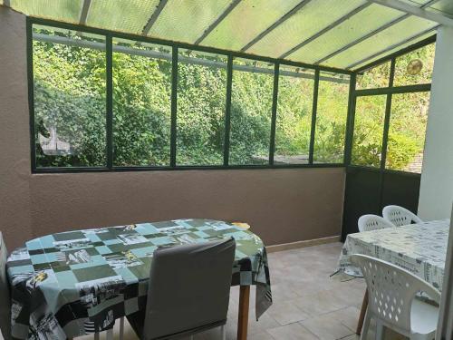 d'une salle à manger avec une table et quelques fenêtres. dans l'établissement Maison de campagne, à Gomméville
