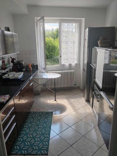 une cuisine avec une table et une fenêtre dans l'établissement Maison de campagne, à Gomméville