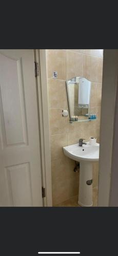 a bathroom with a white sink and a mirror at EDİRNE EYLÜL PANSİYOn in Edirne