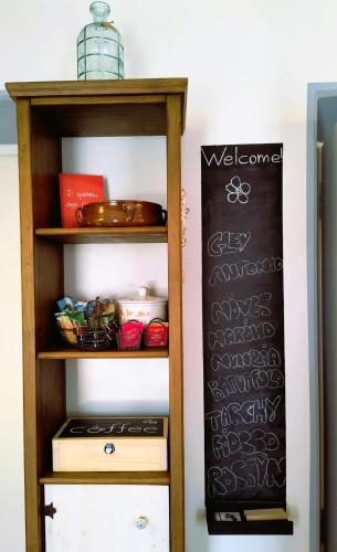 a shelf with a chalkboard next to a kitchen at Il Piano di Mezzo in Manziana