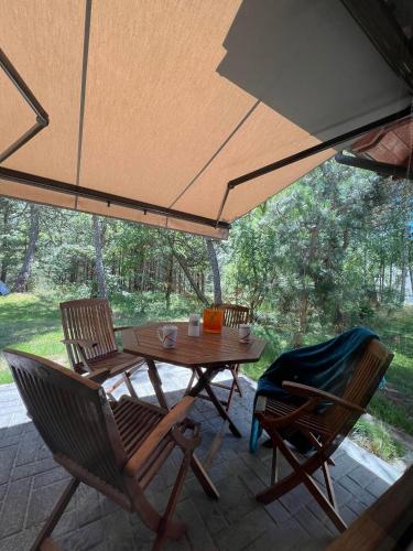 un tavolo e delle sedie sotto un ombrellone in un patio di Poilsis Urbo Nidoje a Nida