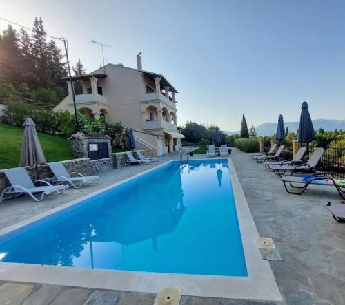 a large swimming pool in front of a house at BOSCO VERDE Corfu Apartments in Gouvia