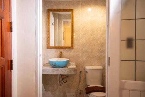 a bathroom with a sink and a toilet and a mirror at JB Home Bangkok - Victory monument in Bangkok
