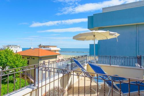 a balcony with a beach chair and an umbrella at Residence Ducale in Rimini