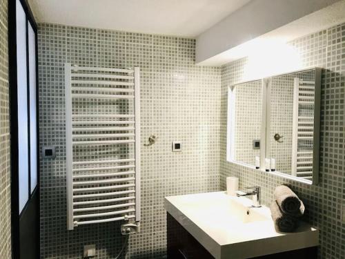 une salle de bain avec un lavabo et un miroir dans l'établissement Appart calme avec vue dégagée, terrasse, clim, parking !, à Sète
