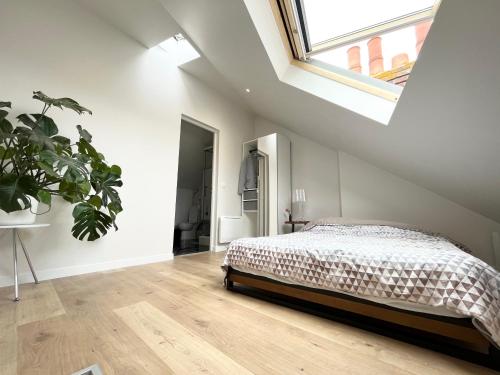 une chambre blanche avec un lit et une fenêtre dans l'établissement Duplex avec vue - Intra-muros Design et authenticité, à Saint-Malo