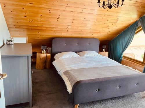 una cama en una habitación con techo de madera en Wild Cottage, en Poiana Mărului