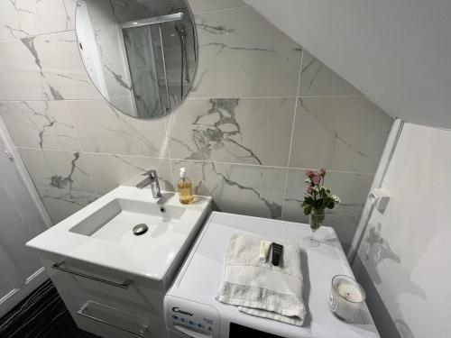 une salle de bain blanche avec un lavabo et un miroir dans l'établissement Duplex avec vue - Intra-muros Design et authenticité, à Saint-Malo