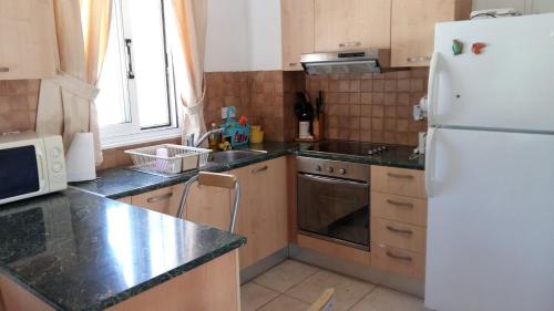 a kitchen with a white refrigerator and a sink at Villa Maya in Paralimni