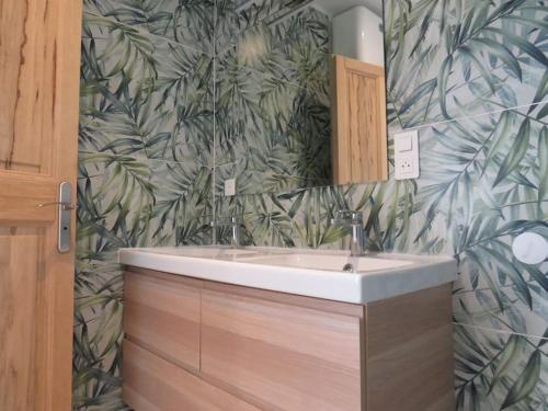 La salle de bains est pourvue d'un lavabo et d'un papier peint feuilleté. dans l'établissement Maison face au Luberon avec piscine - 5 Chambres, à Cabrières-dʼAvignon