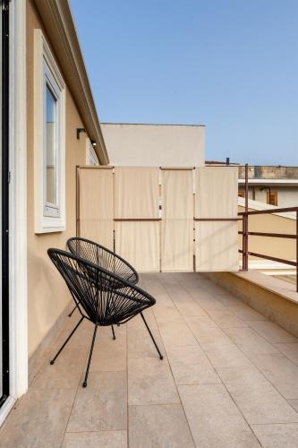 a bench sitting on the balcony of a building at MILLE SUITE GARDEN in Noto