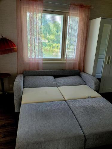 a bed sitting in a room with a window at Rantatalo in Pori