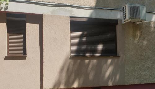 een gebouw met twee ramen met jaloezieën bij Închiriez garsoniera in Regim Hotelier Berceni-Sun Plaza in Boekarest