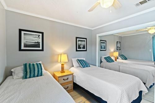 a bedroom with two beds and a mirror at 2-Bedroom Condo on Gulf Shores Beach w/Pool in Gulf Shores