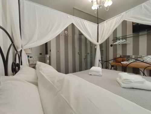 a bedroom with two beds with white sheets and mirrors at Relais Tiaré Bed and Breakfast in Bacoli