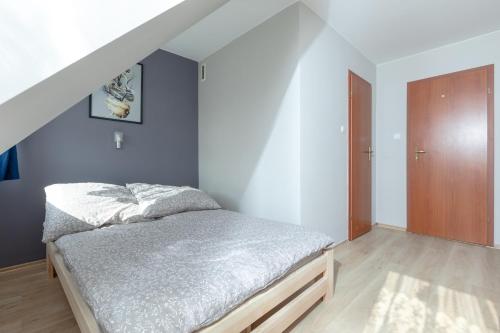 a bedroom with a bed and a wooden door at Pensjonat Jagódka in Trzęsacz