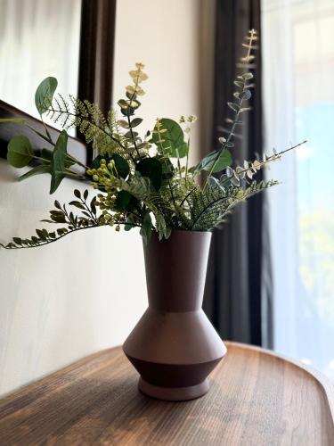 a vase filled with plants sitting on a table at R&G luxury accommodation Varkiza in Vari