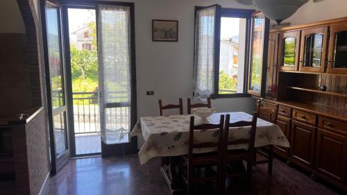 a dining room with a table and chairs and windows at Appartamenti Bella Vista in Quara