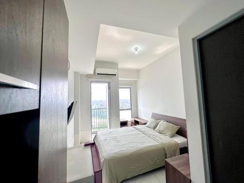a bedroom with a bed and a window at Pleasant Tamansari Prospero Studio Apartment in Sidoarjo by Le Ciel Hospitality in Sidoarjo