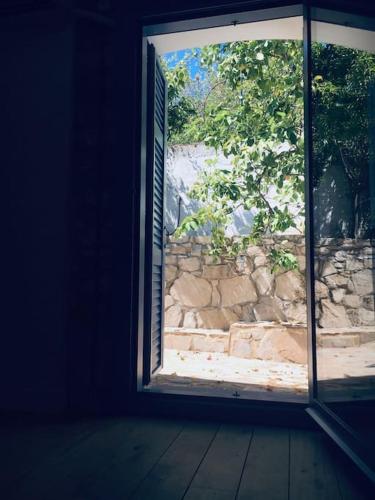 an open window with a view of a stone wall at Lagada-Chios in Lagkáda