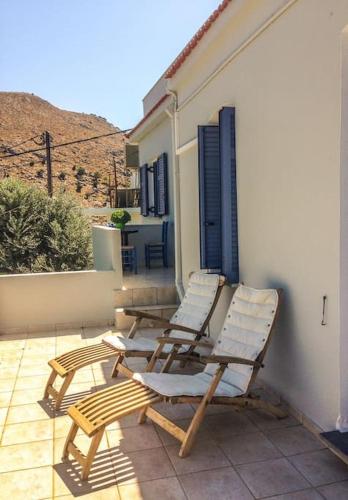 two lounge chairs sitting on a patio with a house at Lagada-Chios in Lagkáda
