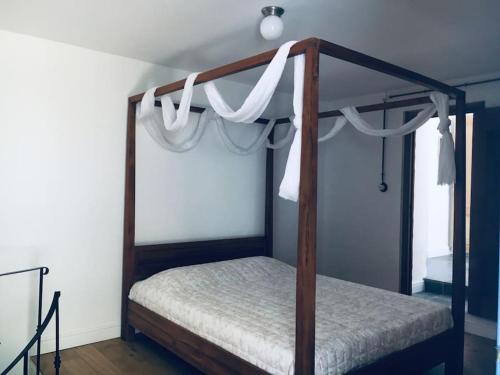 a bedroom with a canopy bed with white curtains at Lagada-Chios in Lagkáda