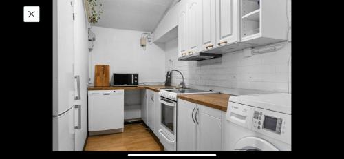 a small kitchen with white cabinets and a sink at 2 bedrooms 1 bathroom kitchen apartment in Stockholm
