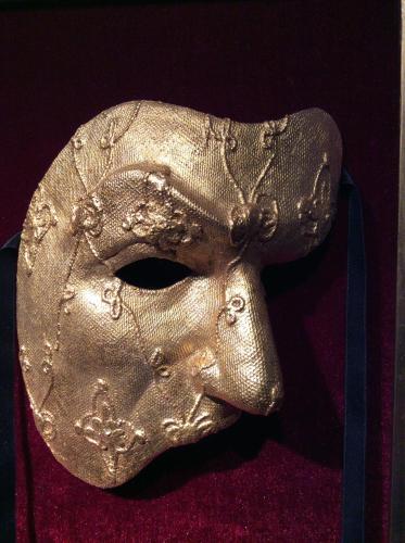 a gold masquerade mask with a blue ribbon at Kullabygdens Bed & Breakfast Höganäs in Jonstorp